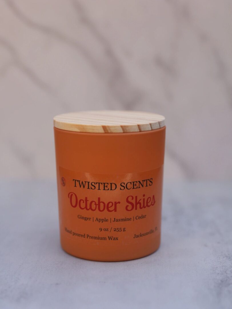 October Skies" candle on a table