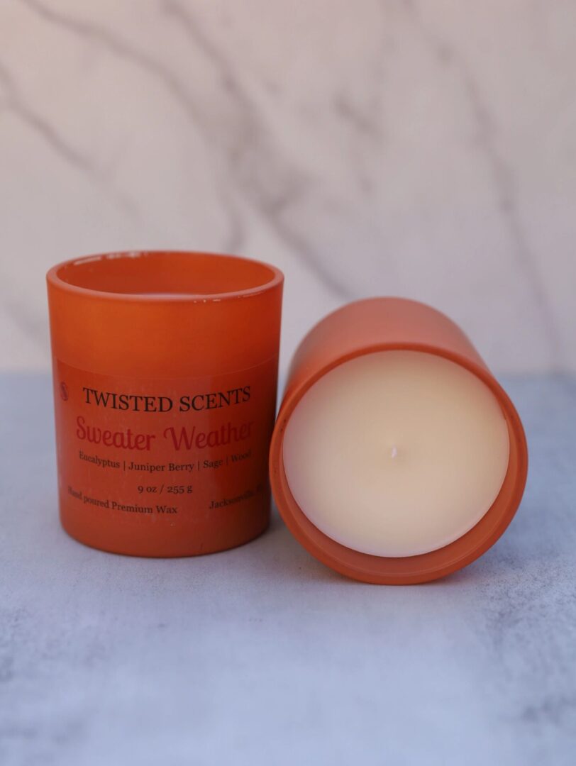 Two orange candles on marble surface